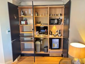 a room with a kitchen with wooden shelves at Hillside Farm Barn in Woking