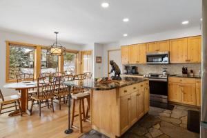 a kitchen with wooden cabinets and a table and chairs at RMR: Three Bear Tracks Home in Teton Village in Teton Village