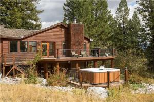 a wooden house with a hot tub on a deck at RMR: Three Bear Tracks Home in Teton Village in Teton Village