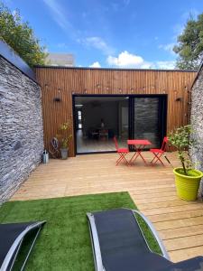 a wooden deck with a table and chairs on it at Cosy home quartier gare lafayette avec spa et sauna privatif in Angers