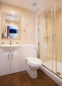 a bathroom with a toilet and a sink and a shower at The Beaufort, Raglan in Raglan