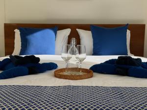 łóżko z dwoma kieliszkami do wina i niebieskimi poduszkami w obiekcie SeaSmile Beach Resort Koh Jum Formerly Sunsmile w mieście Koh Jum