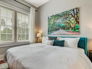 a bedroom with a large white bed and a painting on the wall at The Haywood in Savannah +26 photos