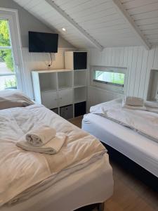 グリュックスブルクにあるDreibogen Ferienhaus Smalandのベッドが2つと壁にテレビがある寝室