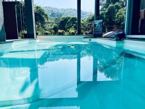 a swimming pool with a view of the mountains at Nyast Valley Resort by Autumleafs, Goa in Arpora