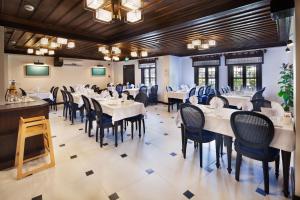 a dining room with white tables and chairs at Sırçalı Hotel in Meram