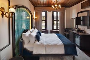 a bedroom with a large bed and a kitchen at Sırçalı Hotel in Meram