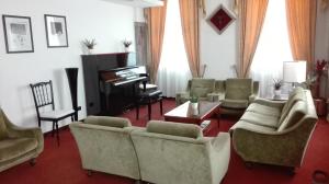 a living room with couches and a piano at Hotel Excelsior in Lanciano