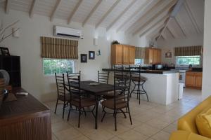 a kitchen and dining room with a table and chairs at Luxury Villa-Sleeps 6-Private Pool in Jolly Harbour