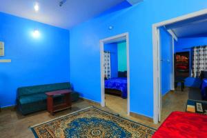 um quarto azul com um sofá e uma cama em Butterfly homestay em Ooty