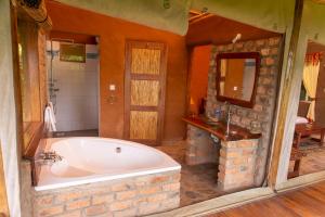 a large bathroom with a tub and a sink at Sharp Island Gorilla Lodge, Lake Bunyonyi in Kashasha