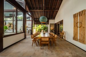 a dining room with a wooden table and chairs at Oceanfront Luxury Villa in Beraban with Private Pool in Krambitan