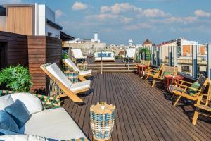 a balcony with chairs and tables on a roof at Axel Hotel Barcelona - Adults Only in Barcelona