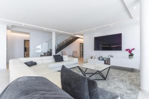 ein Wohnzimmer mit einer weißen Couch und einem Tisch in der Unterkunft Villa Zenha by Atlantic Holiday in Ribeira Brava