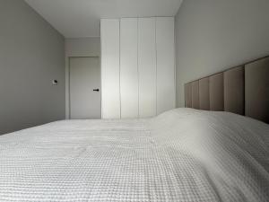 ウォムジャにあるApartament 345の白いシーツが敷かれた大きなベッドのある寝室