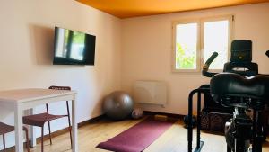 Una habitación con un televisor, una mesa y una cámara. en Studio Wellness & Détente Cosy, en Maubec