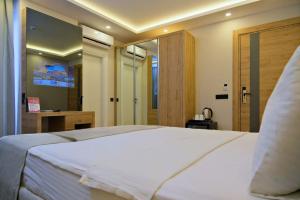 a bedroom with a large white bed and a mirror at La Vita Es Bella in Antalya