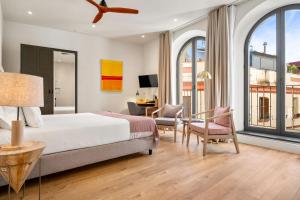 a bedroom with a bed and a desk and chairs at Casa Alhaja by Shiadu in Seville