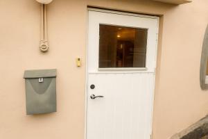 a white door with a window and a trash can at Cozy private house with free parking in Kongsvinger