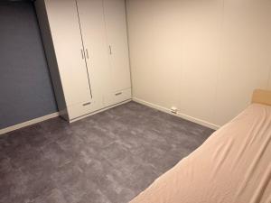 an empty bedroom with white cabinets and a bed at Cozy private house with free parking in Kongsvinger +4 photos