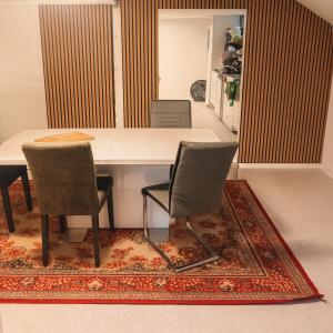 a dining room with a table and two chairs on a rug at Cozy private house with free parking in Kongsvinger
