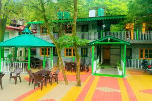 a building with tables and chairs in front of it at Heyan Cedar Woods Nainital in Nainital +25 photos