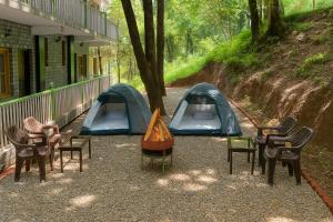 a group of chairs and tents next to a building at Heyan Cedar Woods Nainital in Nainital