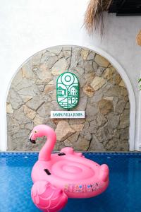 un flamant rose dans l'eau devant une piscine dans l'établissement Sampai Villa Jumpa, à Balong