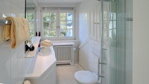 une salle de bain blanche avec lavabo et douche dans l'établissement Luxus Heefwai, à Morsum 133 autres photos