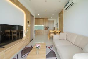 a living room with a white couch and a kitchen at Hue Rustic Homestay with Swimming Pool & Gym Room in Thôn Văn Dương