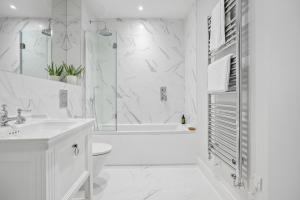 a white bathroom with a shower and a sink at Morford House - Stylish Retreat in the Heart of Exeter in Exeter