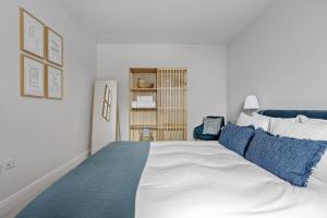 a bedroom with a large white bed with blue pillows at Morford House - Stylish Retreat in the Heart of Exeter in Exeter