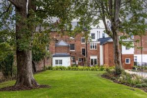a lawn in front of a large brick building at Morford House - Stylish Retreat in the Heart of Exeter in Exeter