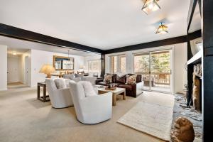 a living room with white furniture and a fireplace at RMR: Teewinot C3 Condo in Teton Village in Teton Village