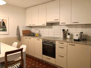 a kitchen with white cabinets and a stove at Old City Gem-Very Comfy Bed-Bakery Downstairs in Bern