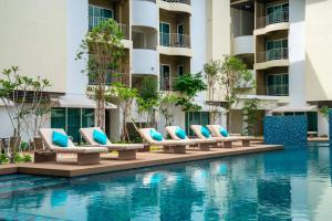 a swimming pool with lounge chairs next to a building at Mercure Langkawi Pantai Cenang in Pantai Cenang +45 photos