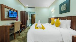 a bedroom with a large white bed and a desk at VERTA Almahbas Hotel in Mecca