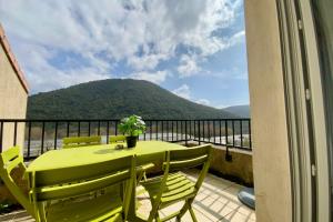 a green table and chairs on a balcony with a mountain at Les Naïades I49 - 2 bedrooms for 5 people ! in Avène