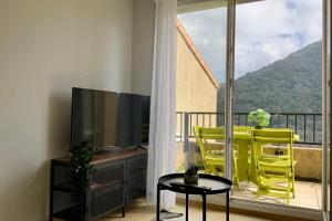 a balcony with a tv and a table and chairs at Les Naïades I49 - 2 bedrooms for 5 people ! in Avène +5 photos