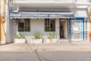 un bâtiment blanc avec un parapluie bleu et des plantes en pot dans l'établissement SDQ Colonial Zone an great find, à Saint-Domingue