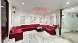 a living room with a red couch in a room at Hotel Kelvish With Free Airport Pickup in New Delhi