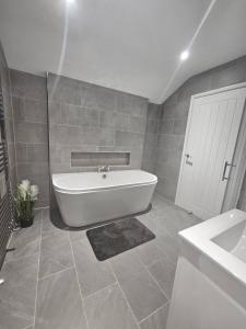 a bathroom with a white tub and a sink at Spacious House with Parking and pool table in Kirton +26 photos
