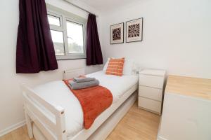 a white bedroom with a bed and a window at Relaxing 3-Bed Family Stay in Basingstoke in Worting