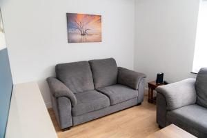 a living room with a couch and a chair at Relaxing 3-Bed Family Stay in Basingstoke in Worting
