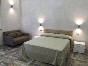 una camera con letto, sedia e luci di Baglio Bonfiglio a Palermo