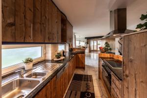 a kitchen with wooden cabinets and a sink at Chalet Gletschermoos - Summer Card included in Zell am See