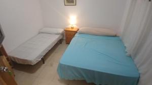 Dos camas en una habitación con una lámpara sobre una mesa. en Habitacion 3 personas en Toledo, en Toledo 11 fotos más