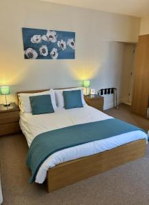 a bedroom with a large bed with two nightstands and two lamps at Peel House Apartments - Great for Professionals & Weekends Away in Burton upon Trent