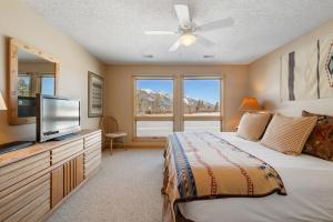 una camera da letto con un letto e una TV a schermo piatto di RMR: Greyling 4513 Condo in The AspensWilsonWY a Wilson