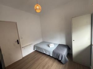 een kleine slaapkamer met een bed en een spiegel bij Apartamento Central Rainha in Caldas da Rainha